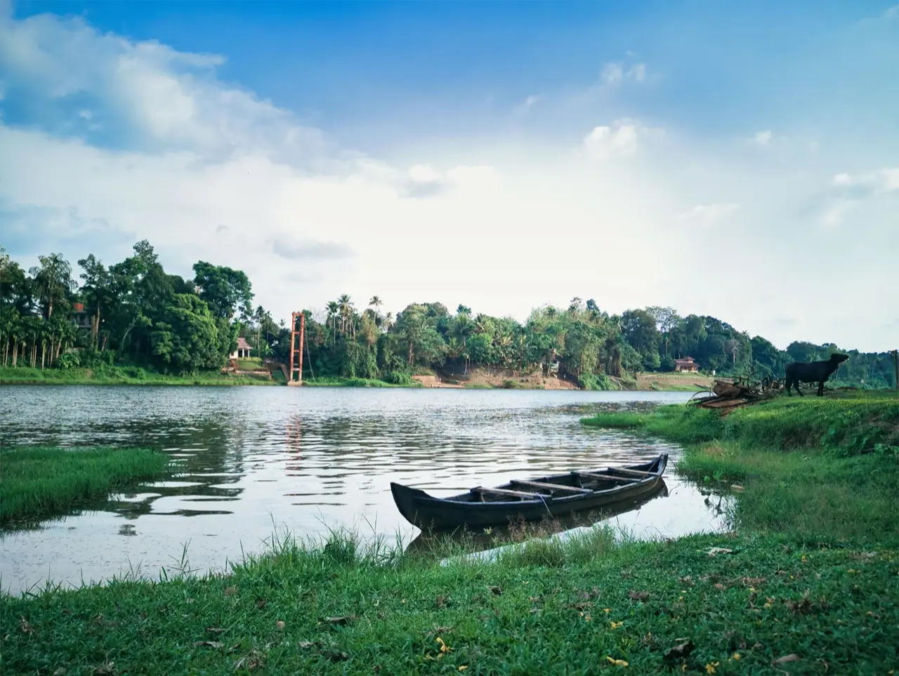 A quiet lake with a wooden boat in Kerala